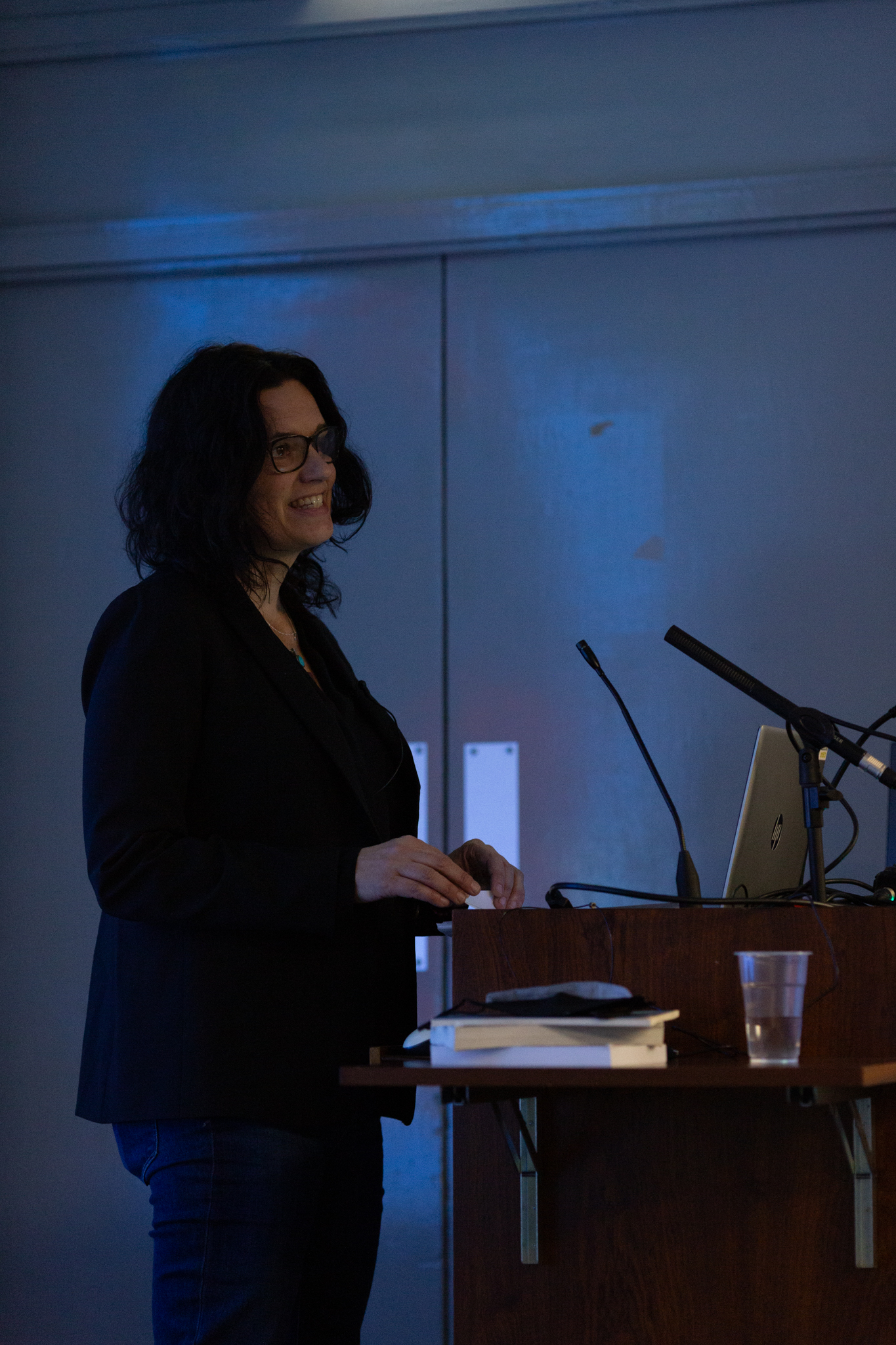 Leanne Betasamosake stands next to a microphone speaking to an audience.