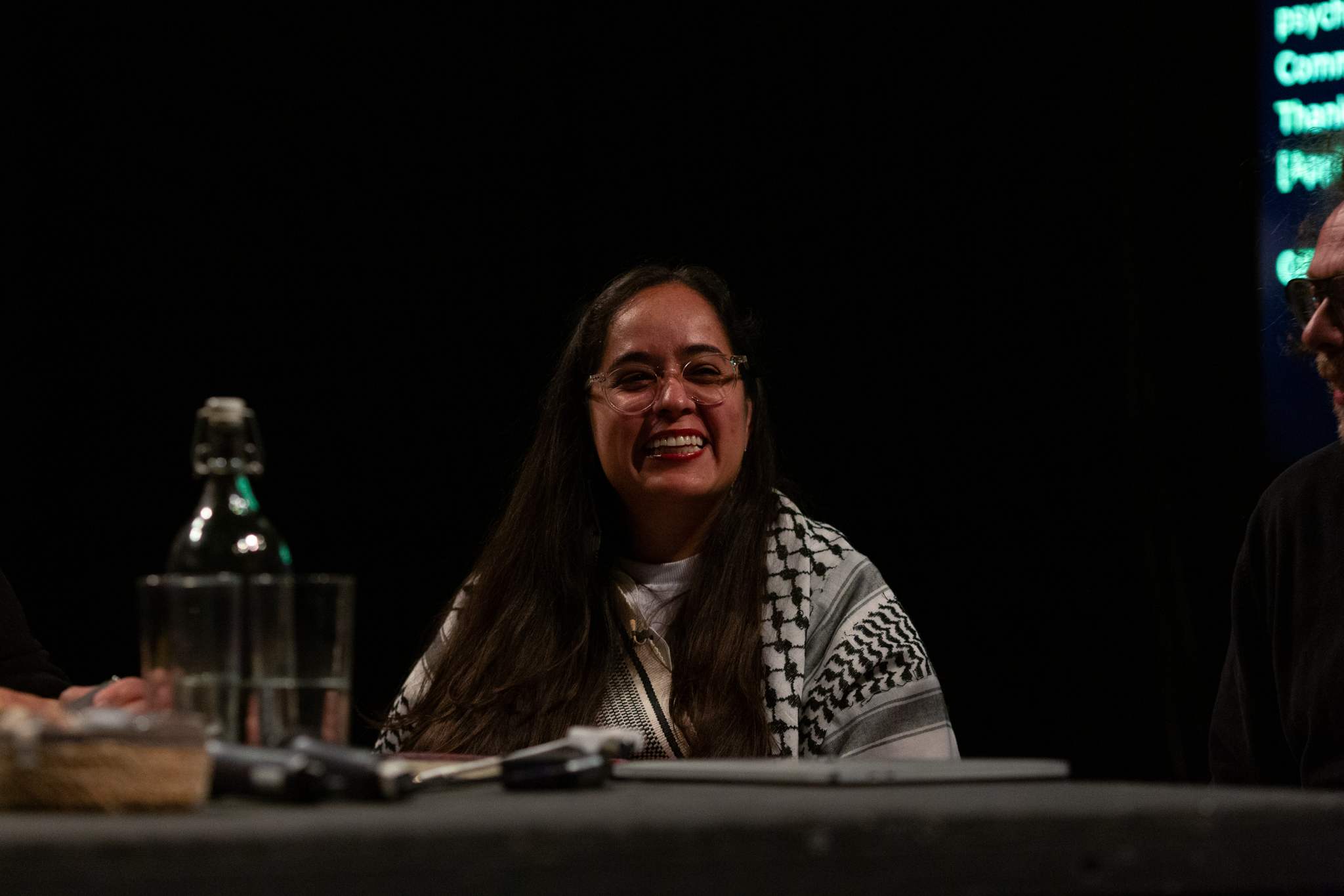 Geni Núñez smiles broadly while in a discussion event with Amilcar Packer