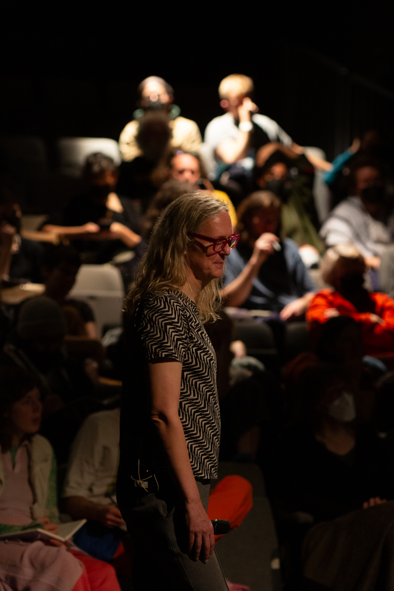 Mijke van der Drift stands with an audience behind them in a seating bank.