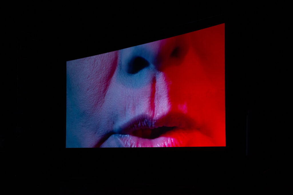 Still image from film screening of "Oriana". Close up of a mouth with lips slightly parted