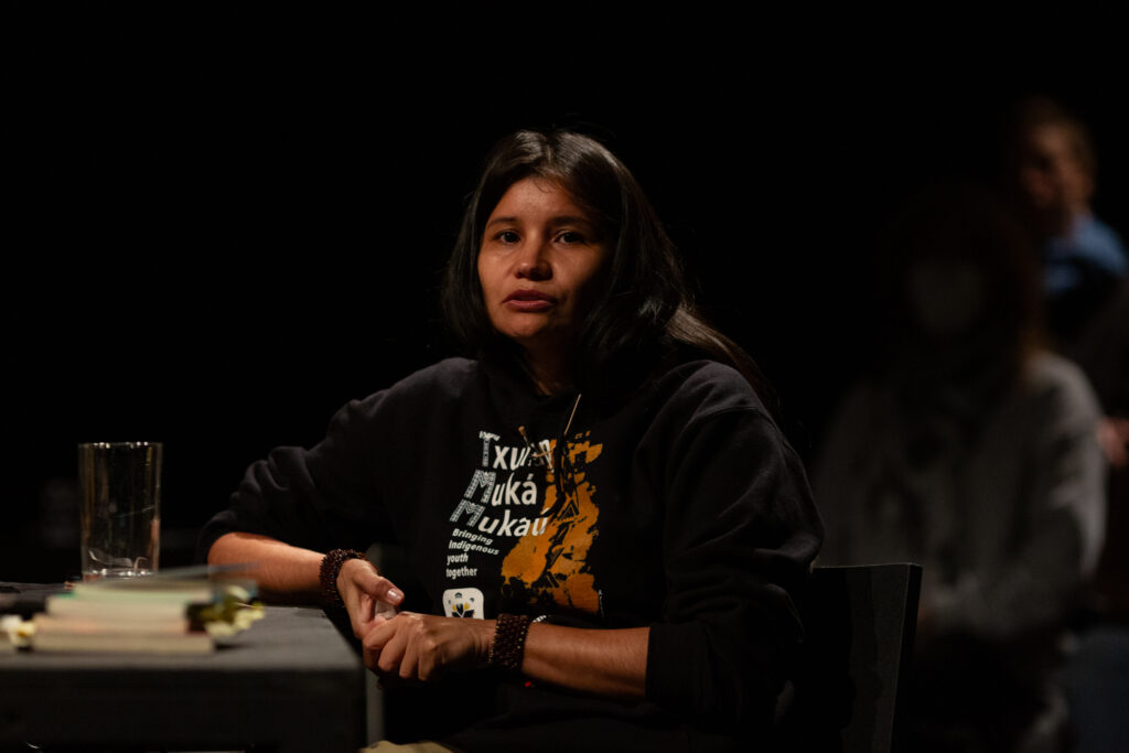 Arissana Pataxó is sitting talking to an audience.