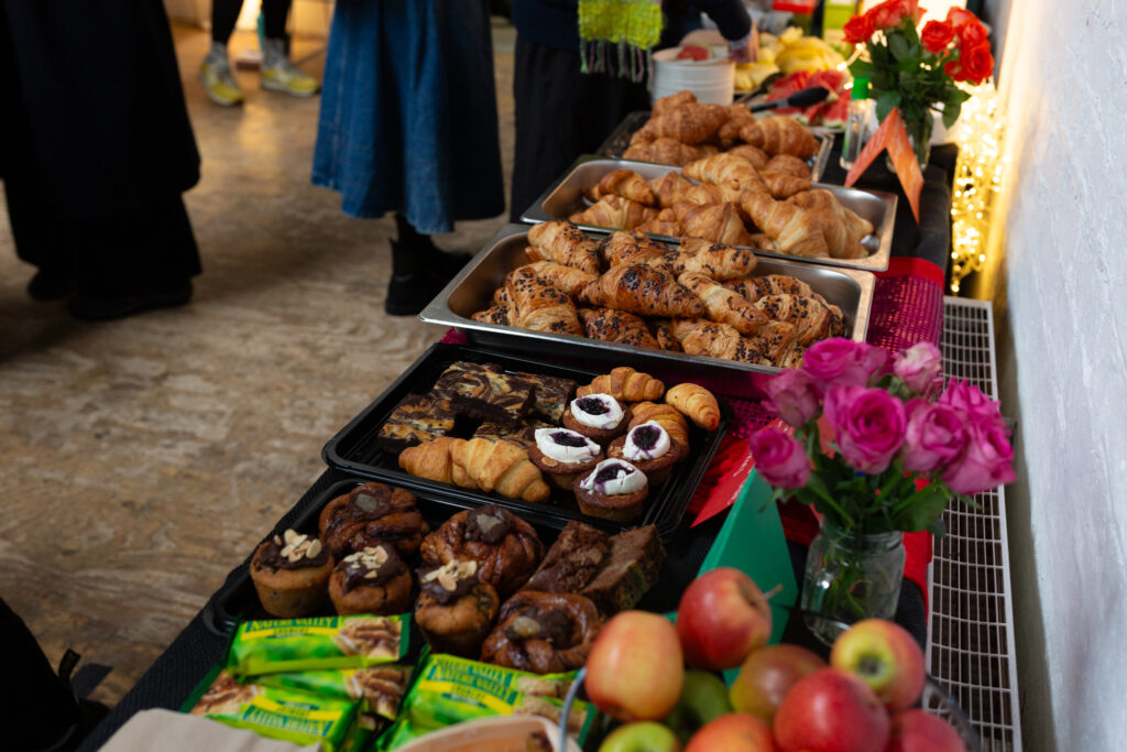 An array of bakery items are displayed on metal and plastic trays.