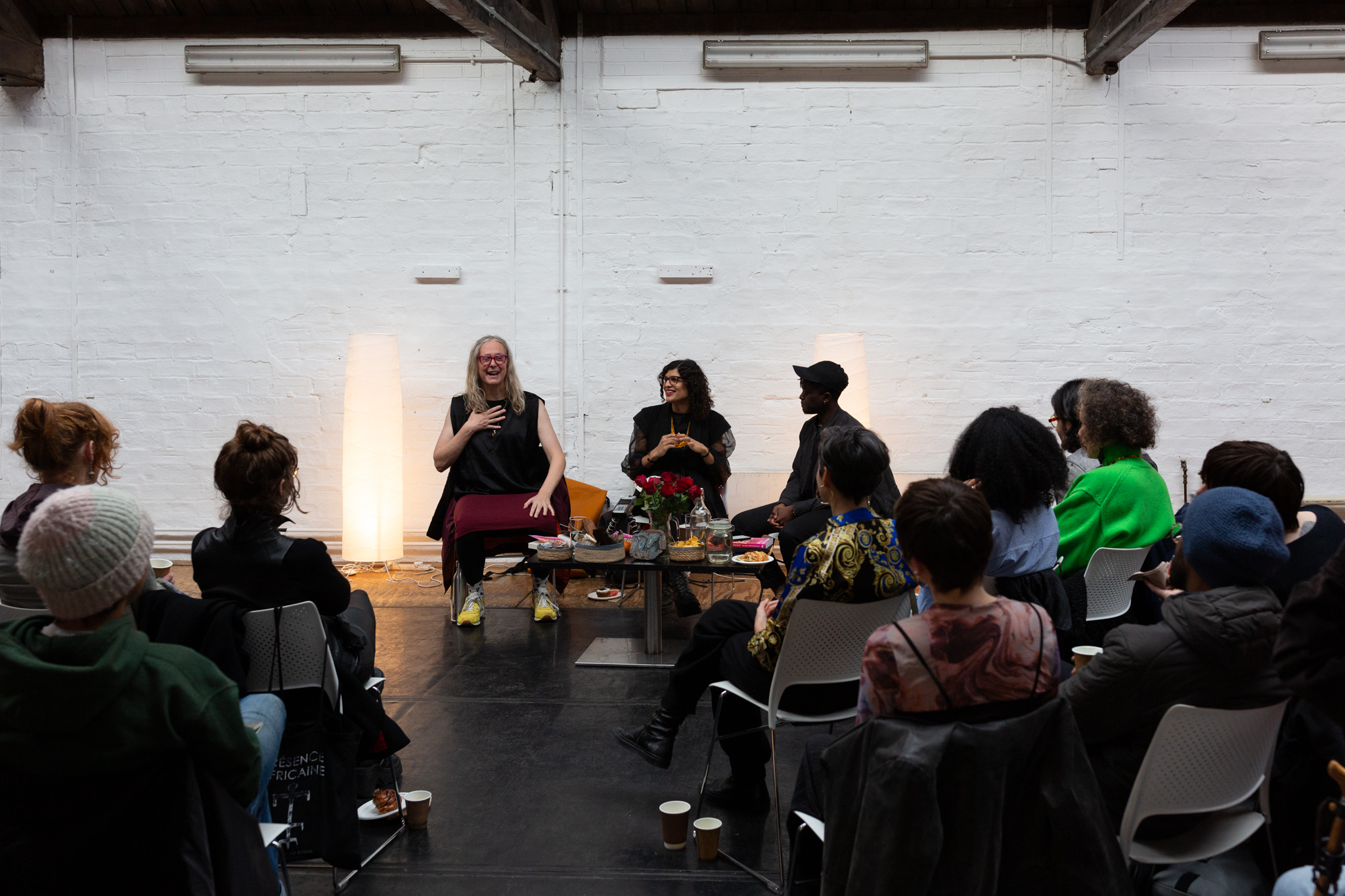 Nat Raha, Mijke van der Drift and Jay Bernard sit in discussion with an audience facing towards them. Between them is a low table with red roses, water and snacks.