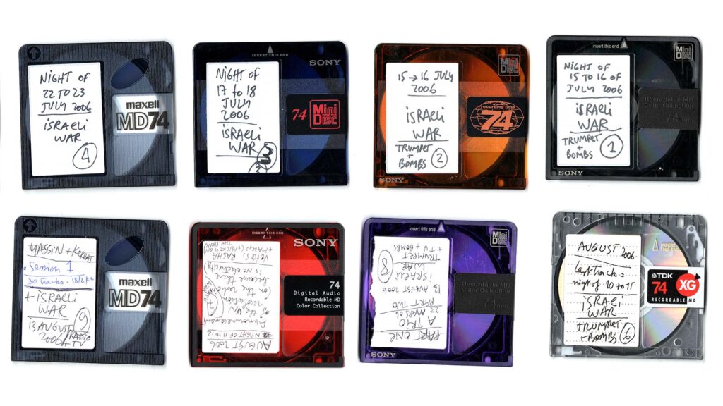 Various mini discs sat on a white background, they are hand labelled with text that indicates they're from the Israel Lebanon war from 2006.