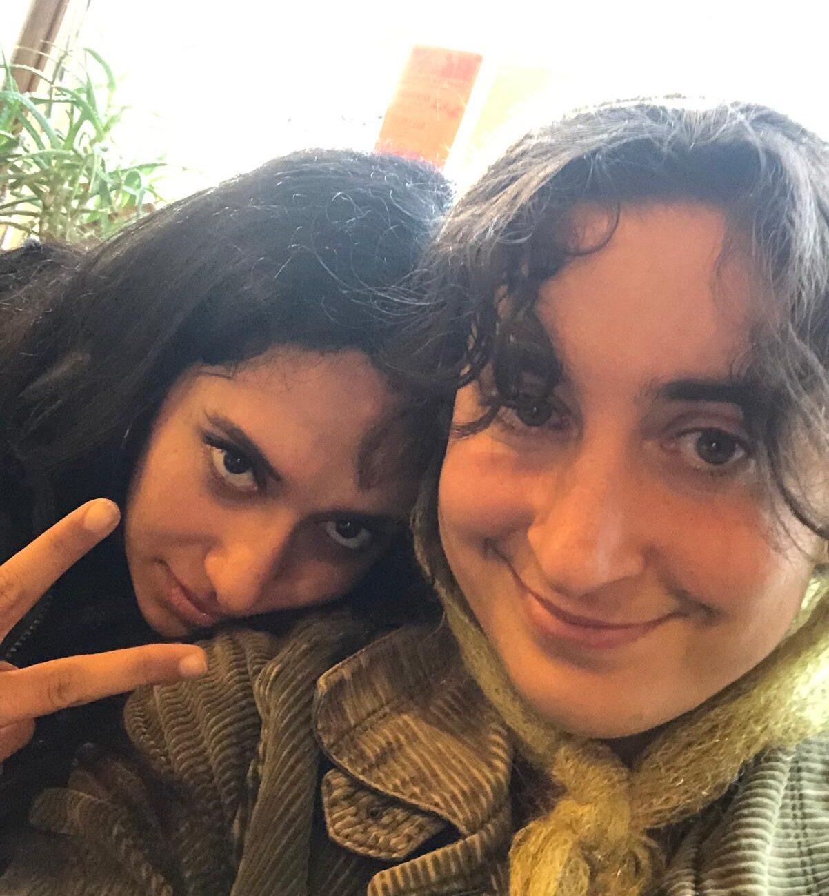 Masa and Hajar together in a selfie looking at the camera. Hajar rest head on Masa's shoulder and does v sign at camera